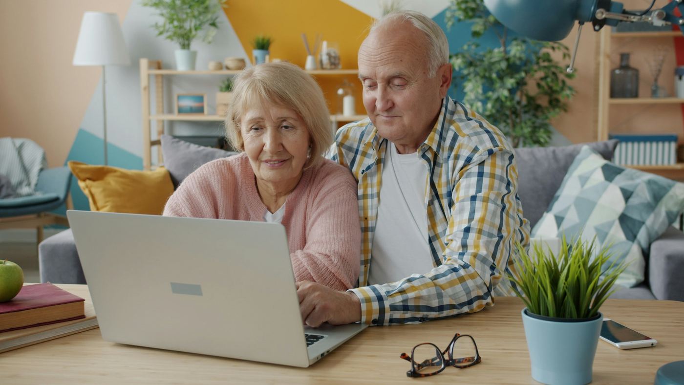 An older couple planning together on a laptop at home